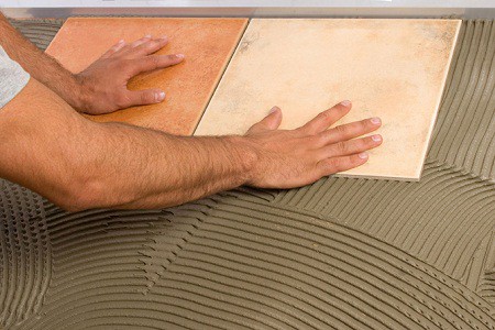 Après avoir appliqué la solution avec une spatule en peigne, nous fixons les carreaux Après avoir appliqué la solution avec une spatule en peigne, nous fixons les carreaux