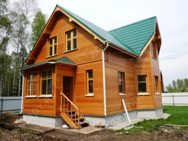 Revêtement de la façade d'une maison en bois avec bardeaux Revêtement de la façade d'une maison en bois avec bardeaux