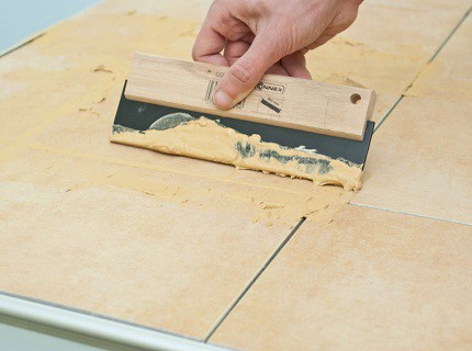 Jointoiement des joints avec une spatule en plastique Jointoiement des joints avec une spatule en plastique