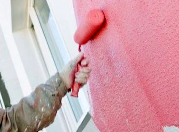 Sur la photo - peinture de la façade avec un rouleau Sur la photo - peinture de la façade avec un rouleau