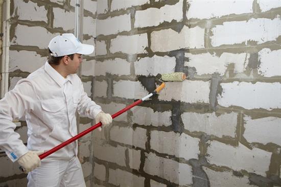 Sur la photo - le processus d'amorçage des murs en béton mousse Sur la photo - le processus d'amorçage des murs en béton mousse