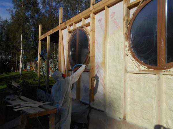 Application d'un isolant en mousse liquide sur le mur de la maison. L'équipement de protection individuelle est essentiel ici. Application d'un isolant en mousse liquide sur le mur de la maison. L'équipement de protection individuelle est essentiel ici.