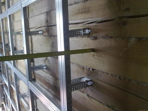 Tournage sur un mur en bois à partir d'un profilé métallique. Des panneaux isolants seront ensuite posés dans les zones libres Tournage sur un mur en bois à partir d'un profilé métallique. Des panneaux isolants seront ensuite posés dans les zones libres