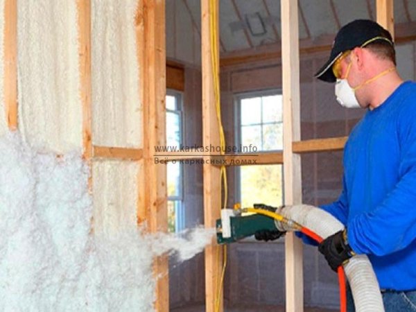 Sur la photo, le spécialiste applique de la mousse de polyuréthane sur une cloison en bois