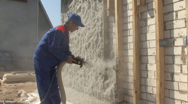Pulvérisation d'isolant en mousse de polyuréthane sur les murs d'une maison Pulvérisation d'isolant en mousse de polyuréthane sur les murs d'une maison