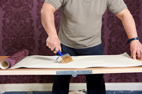 Ensuite, avec un pinceau, de la colle déjà déposée est appliquée sur la bande de papier peint. Ensuite, avec un pinceau, de la colle déjà déposée est appliquée sur la bande de papier peint.